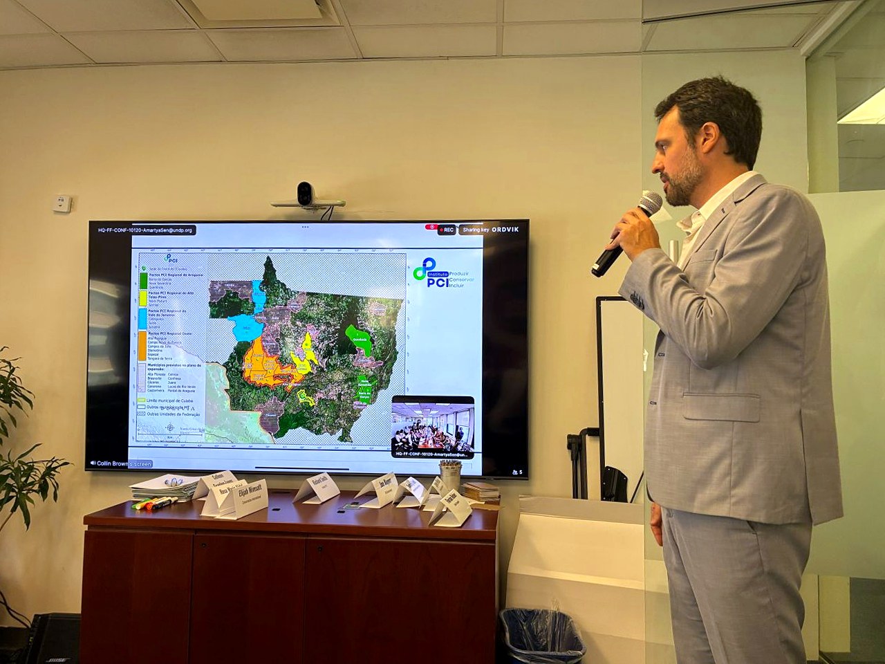 Richard Smith, do Instituto PCI, fala ao microfone diante de tela com o mapa dos Pactos PCI em Mato Grosso